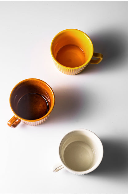 Aerial view of 3 Vintage Style Ribbed Mugs in Tumeric Latte, Vanilla Steamer & Caramel Mocha colors.