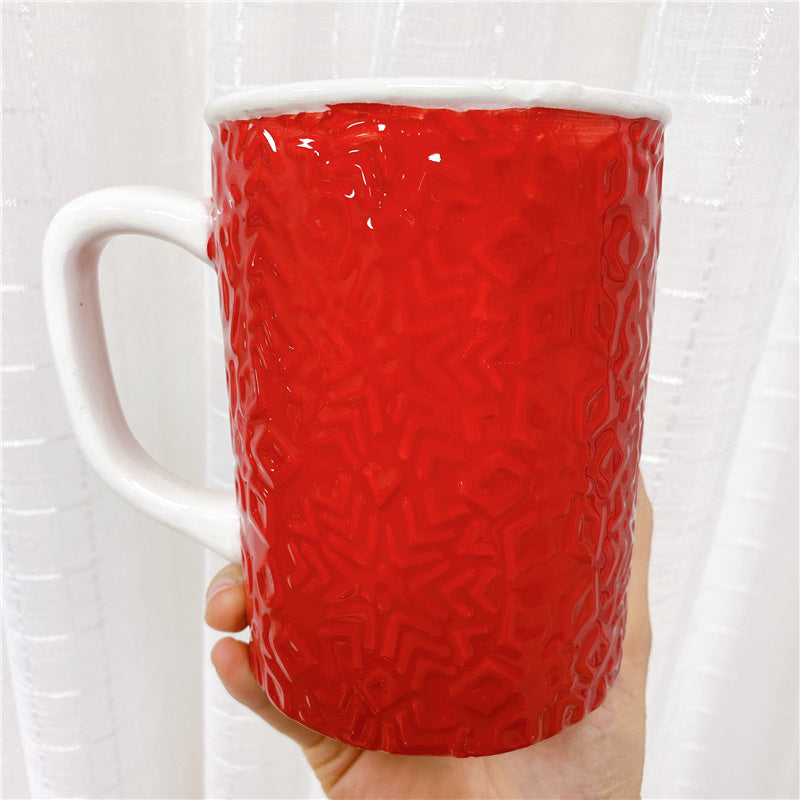 Back side view of the Red Santa Clause shaped mug, with white C-handle.