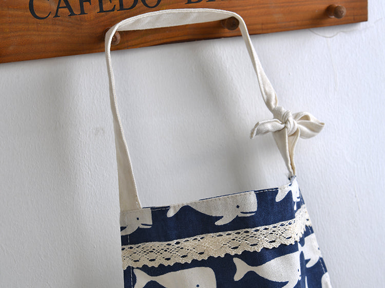 Front View of White Apron Straps on Blue Apron with White Whale Pattern on it