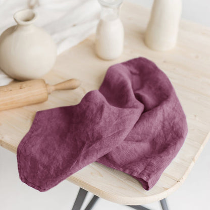 Linen Tea Towel on tanle along with ceramic vase, glass of milk, and rolling pin in the background