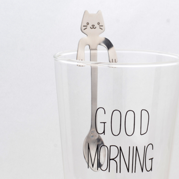 Hanging Cat Spoon in Silver on glass cup that says good morning