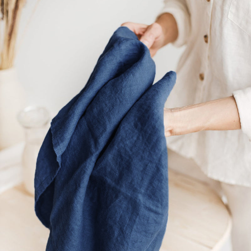 Woman's hands holding linen tea towel.