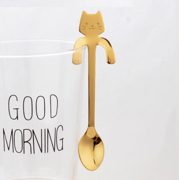 Hanging Cat Spoon in Gold on glass cup that says good morning