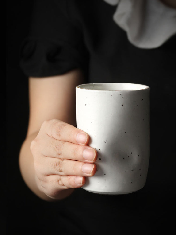 Person's hand holding a Misshapen Magic Japanese Style Tea Cup Mug