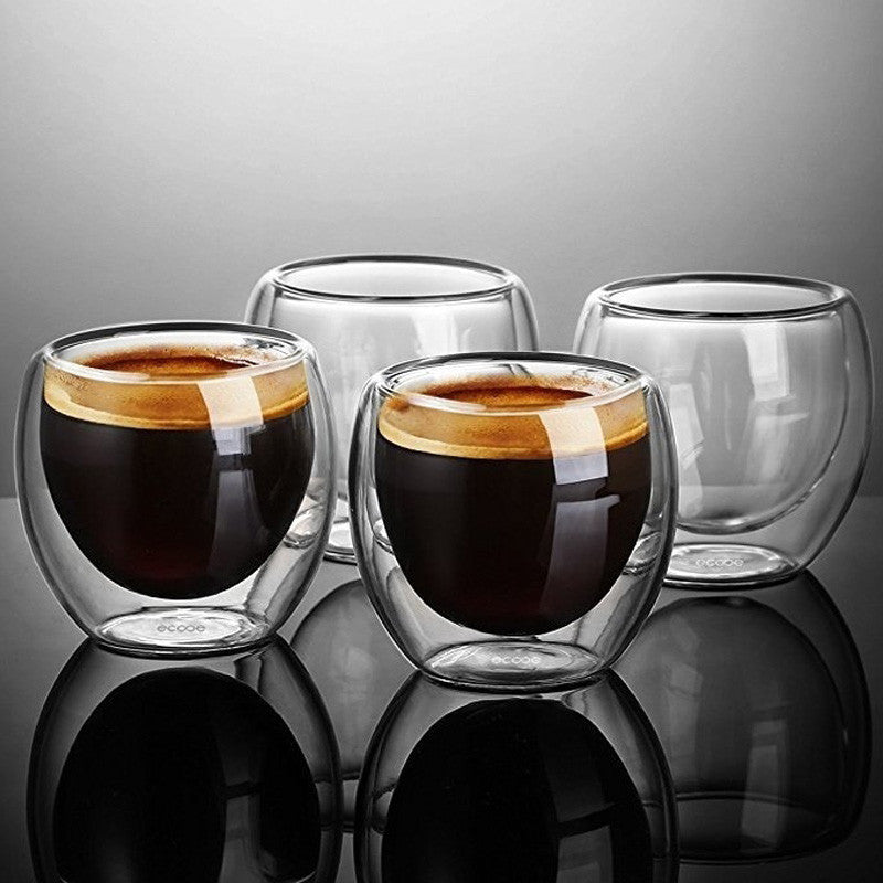 4 Double-Walled Glass Espresso Glasses. The 2 in the front are filled with espresso and the 2 behind those are empty.