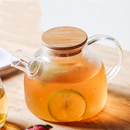 Small Clear Glass Pitcher (33.81 fl oz / 1000ml) With Bamboo Lid. There is iced tea inside of the pitcher.