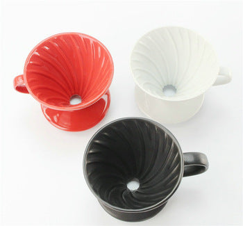 3 Ceramic Pour Over Coffee Filters in aerial view, forming an upside down triangle shop. On the top right there is a red ceramic filter, on the top left there is a white ceramic filter, and on the bottom there is a black ceramic coffee filter.  