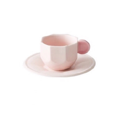 Pink Octagonal Shaped Mug with Macaron Handle and saucer on white background.