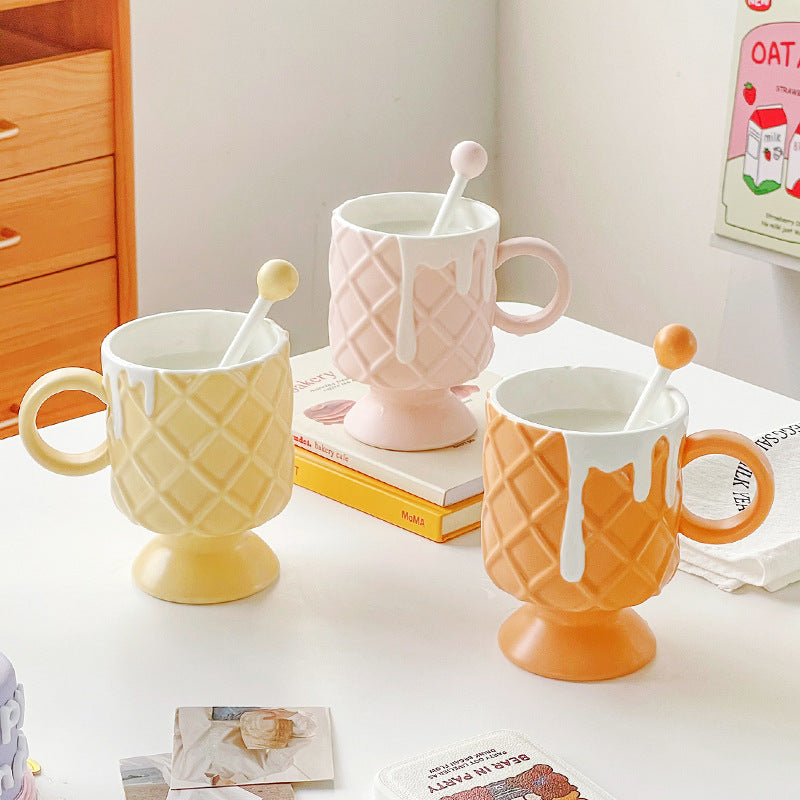 3 Ice Cream Coffee Cups With Mixing Spoons on a table that has books stacked on it and other pieces of paper.