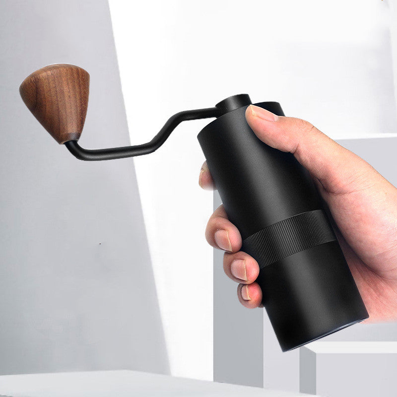 Person's hand holding a Black Compact Manual Coffee Grinder