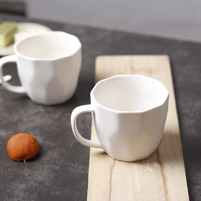 2 White Diamond-Shaped Ceramic Mugs on a bench