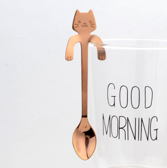 Hanging Cat Spoon in Rose Gold on glass cup that says good morning