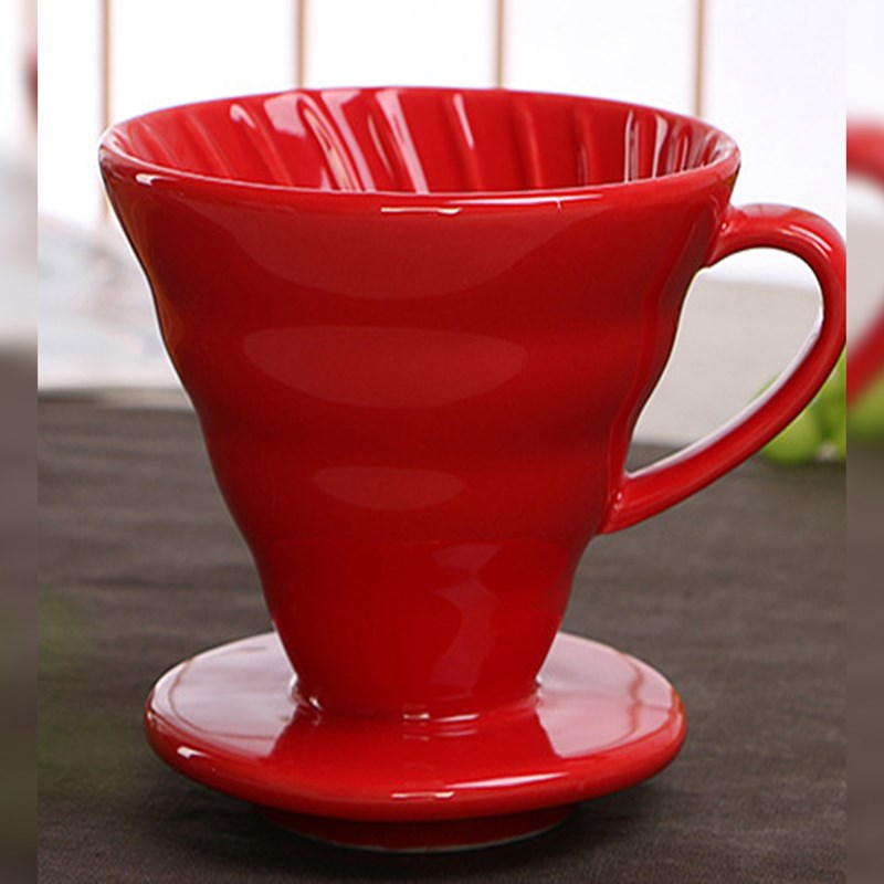 Red Ceramic Pour Over Coffee Filter sitting on a table top covered in a dark gray table cloth.