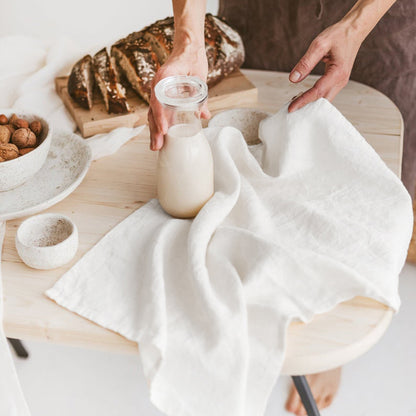 Linen Tea Towel on Table with woman, jar of milk, and bread on the table.