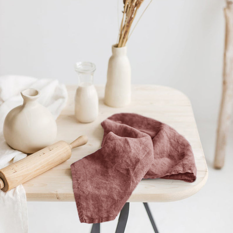 Linen Tea Towel on tanle along with ceramic vase, glass of milk, and rolling pin in the background