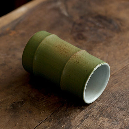 Handmade Ceramic Bamboo Shoot Shaped Cup lying on side on table.