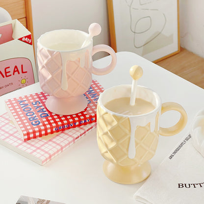 2 Ice Cream Coffee Cups With Mixing Spoons on a table that has books stacked on it and other pieces of paper.