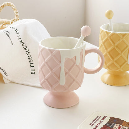 2 Ice Cream Coffee Cups With Mixing Spoons on a table with a bread bag, weaved basket, and book in the bottom right corner.